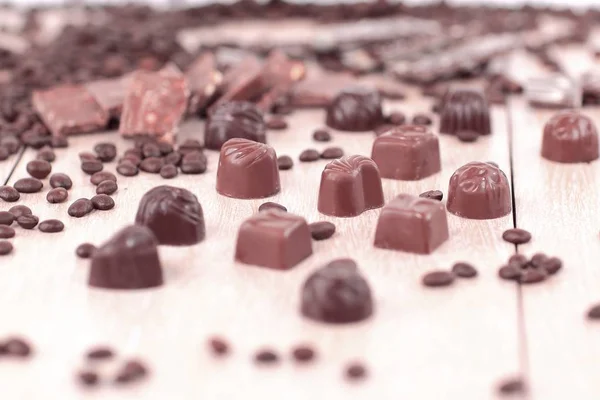 Imagen de fondo de grano de café negro y dulces de chocolate en wo — Foto de Stock