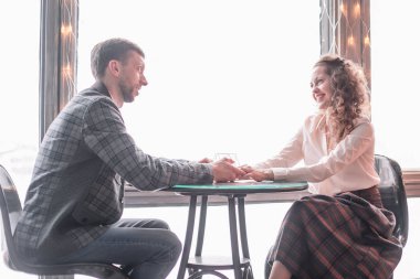 rahat bir kafede bir masada oturan aşık genç çift.