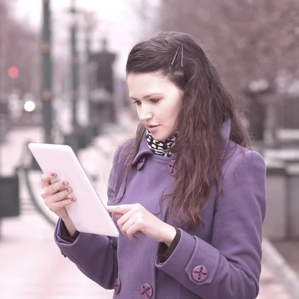 Lachende vrouw met behulp van digitale tablet staande op stad straat — Stockfoto