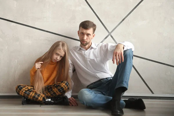 Vater und kleine Tochter sitzen zusammen an der Wand — Stockfoto