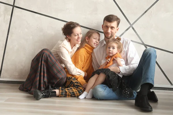 Família feliz sentado no chão em uma nova casa na véspera de Natal — Fotografia de Stock