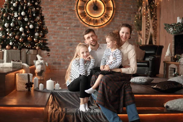 Família feliz sentado no sofá na sala de estar na véspera de Natal — Fotografia de Stock