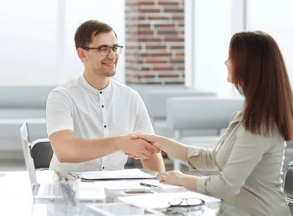 Handshake of a businessman and businesswoman sitting at office Desk — Stock Photo, Image