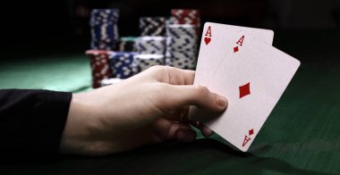 portre. Casino fişi ve iskambil oyuncu elinde.