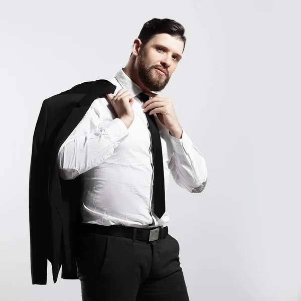 Businessman holding his jacket over his shoulder and straightens his tie — Stock Photo, Image