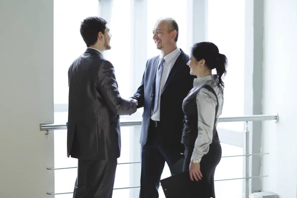 Team di lavoro sorridente guardando un grafico finanziario — Foto Stock