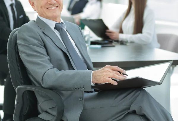 Senior-Geschäftsmann mit Klemmbrett auf dem Hintergrund des Büros — Stockfoto