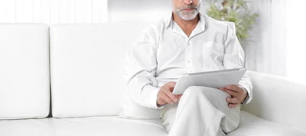 Empresário sênior com tablet digital sentado no sofá — Fotografia de Stock
