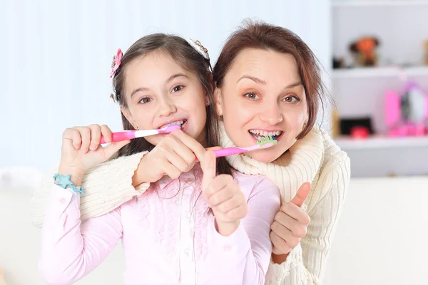 Mamá y su hija cepillarse los dientes.foto con espacio para copiar —  Fotos de Stock