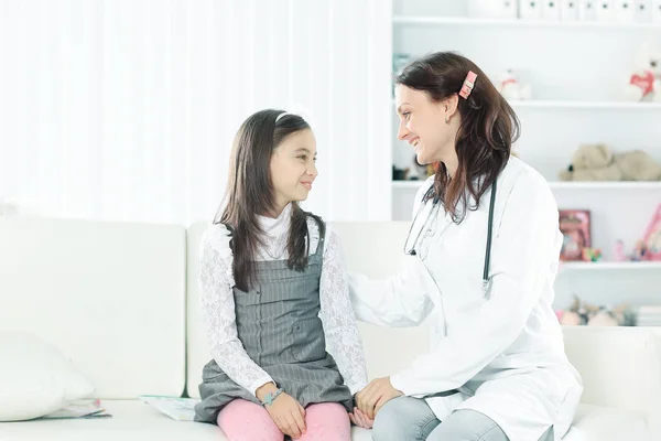 Pediatra, falando positivamente com uma menininha. Foto com espaço de cópia — Fotografia de Stock