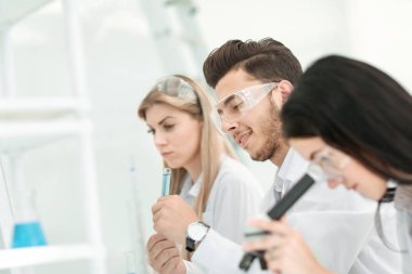 yakın up.a grup genç bilim adamı laboratuvarda deneyler yapmak.