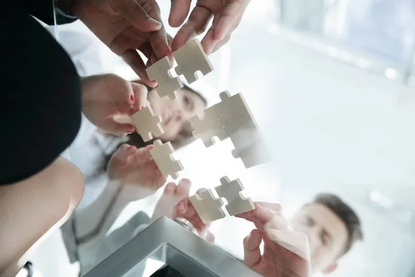 Onderaanzicht. Business team vouwen puzzelstukjes. . — Stockfoto