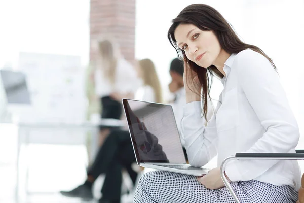 Sorridente mulher de negócios com laptop no fundo borrado — Fotografia de Stock