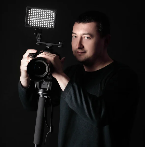 professional photographer with camera on tripod.isolated on black background