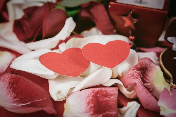 Anel, vela e rosa em um fundo de pétalas de rosa — Fotografia de Stock