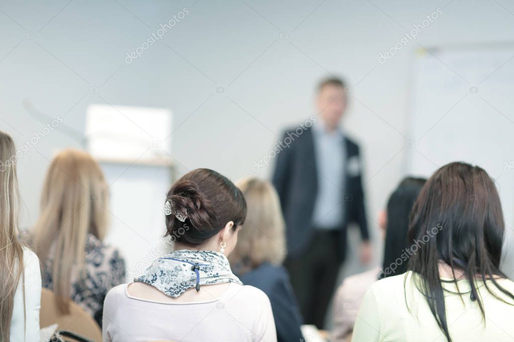 background image of a businessman speaking at a business seminar.