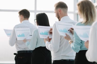 yakın çekim. finansal raporlar doğrultusunda ayakta, çalışanlarla.