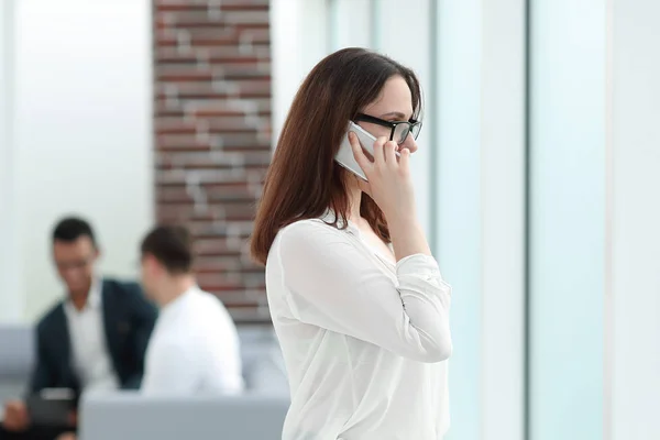 Executiva mulher de negócios falando no smartphone enquanto está no escritório . — Fotografia de Stock