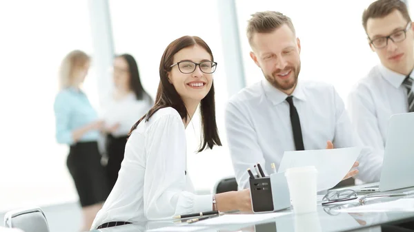 Equipo de jóvenes gerentes sentados en una mesa en el centro de negocios . — Foto de Stock