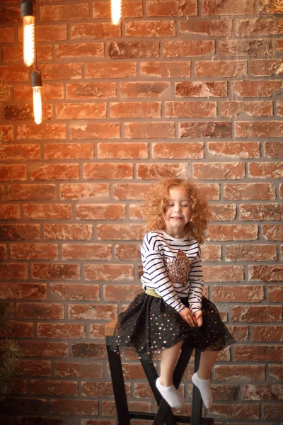 Potret seorang gadis kecil di latar belakang dinding bata . — Stok Foto