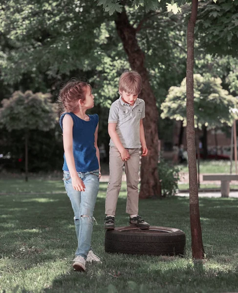 Irmãozinho e irmãzinha em pé no Parque Infantil — Fotografia de Stock