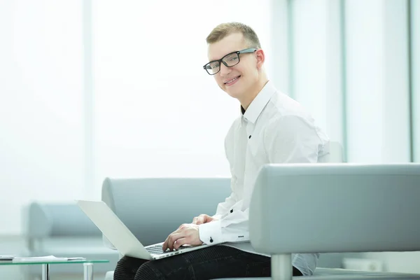 Biznesmen z laptopa siedząc w holu centrum biznesowe — Zdjęcie stockowe