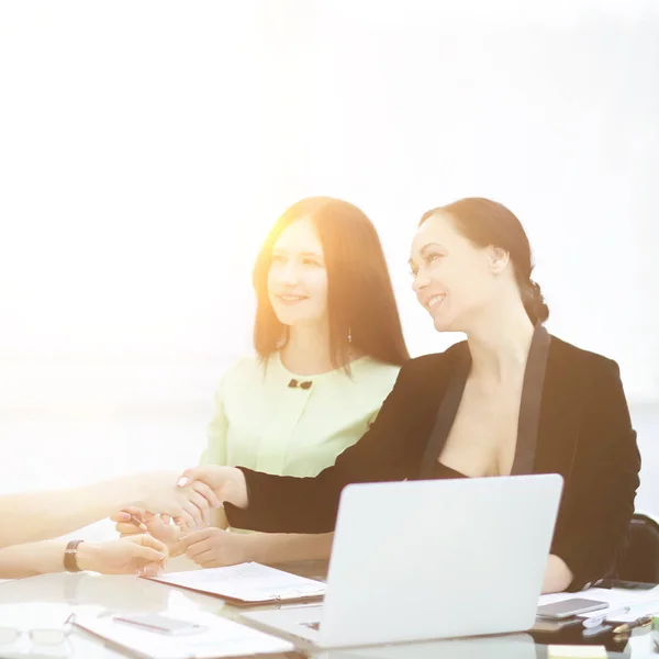 Apretón de manos de los socios comerciales en su Desk.woman y negocio — Foto de Stock