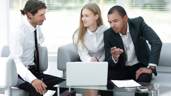 Geschäftsteam diskutiert Informationen mit Laptop — Stockfoto