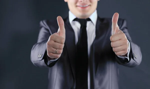 Close up.smiling businessman showing thumbs up.isolated on black — Stock Photo, Image