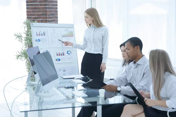 Successful employee is standing by flipchart in office — Stock Photo, Image