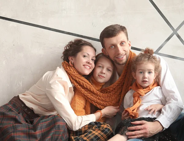 Padres felices con sus hijas sentadas en el suelo en un nuevo apartamento — Foto de Stock