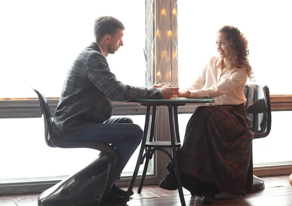 Belo jovem casal sentado a uma mesa em um café acolhedor — Fotografia de Stock