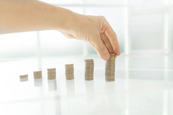 Närbild. affärsman stapling mynt i högar på ett glasbord — Stockfoto