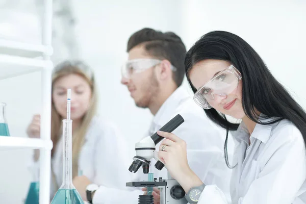 Vrouwelijke wetenschapper gebruikt een microscoop in het laboratorium — Stockfoto