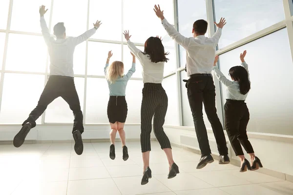 Posteriore view.happy business team, divertirsi in un nuovo ufficio luminoso . — Foto Stock