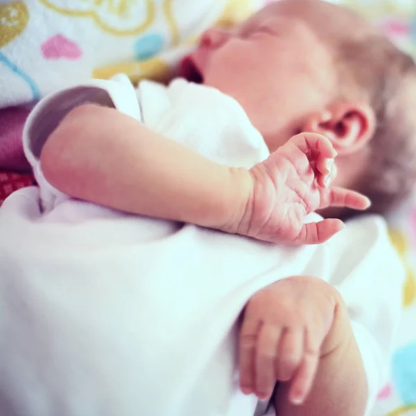 Schattige pasgeboren baby liggend op een deken in de wieg. — Stockfoto