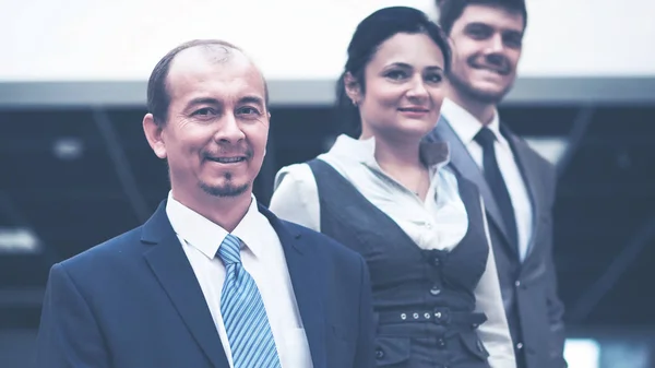 Empregados sorrindo em pé em torno de seu gerente — Fotografia de Stock