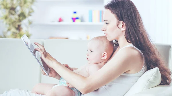 Feliz madre mostrando sus fotos del bebé del año de edad en la tableta digital — Foto de Stock