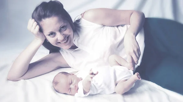 Conceito de felicidade familiar - mãe feliz deitada ao lado do bebê em — Fotografia de Stock