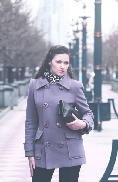 Ragazza in Fioletovo cappotto autunno con una borsa del Parco — Foto Stock