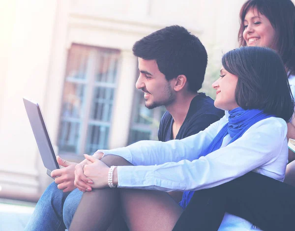 Gruppe fröhlicher Studenten mit Laptop vor dem Hintergrund der Hochschule — Stockfoto