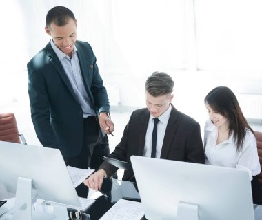 İş ekibi iş yerinde iş belgelerini tartışıyor.