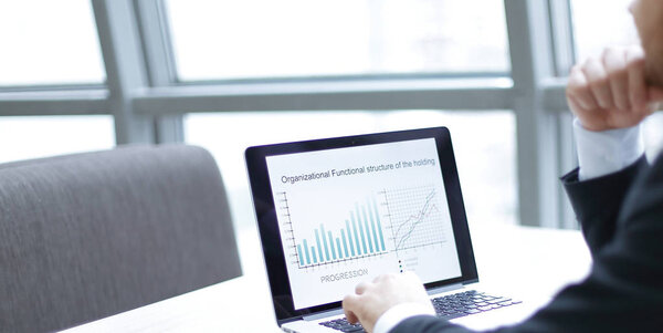 бизнесмен, работающий с финансовыми данными на ноутбуке
.