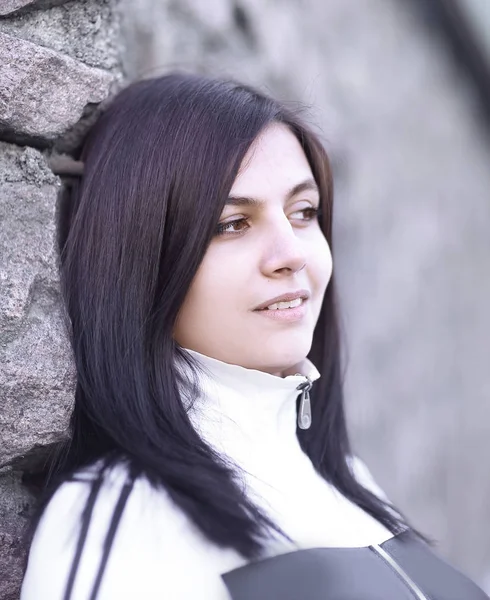 Portrait of sad young woman on stone wall background — Stock Photo, Image