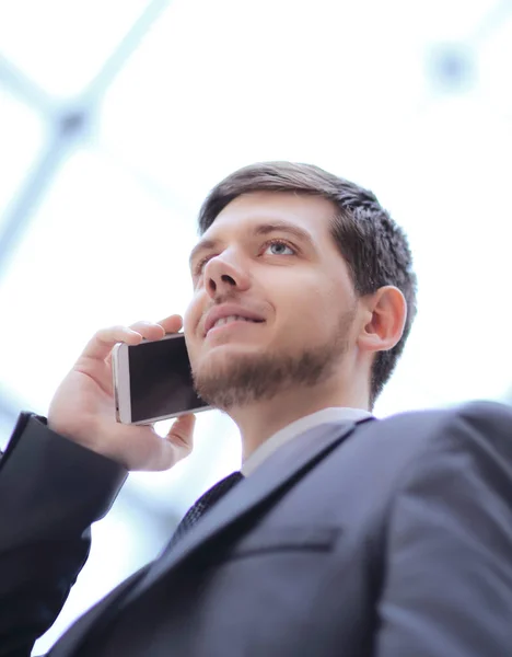 Pracownik biurowy, słuchając jego rozmówca telefon z koncentracji stojąc przy oknie — Zdjęcie stockowe