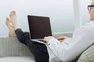 up.a adam inşaat üstünde onun oturma odasında bir dizüstü bilgisayar kapatmak.