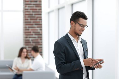 ofis pencere yakınındaki smartphone konumu olan genç işadamı.