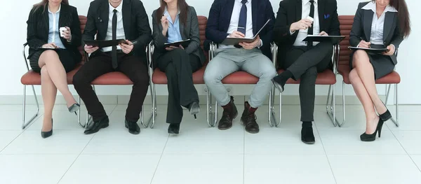 Бізнес-команда з кишенями, що сидять поспіль — стокове фото