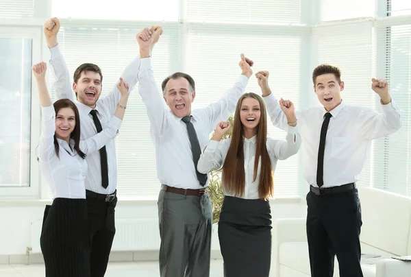 Group of happy young people in formal wear celebrating, gesturing, keeping arms raised — Stock Photo, Image