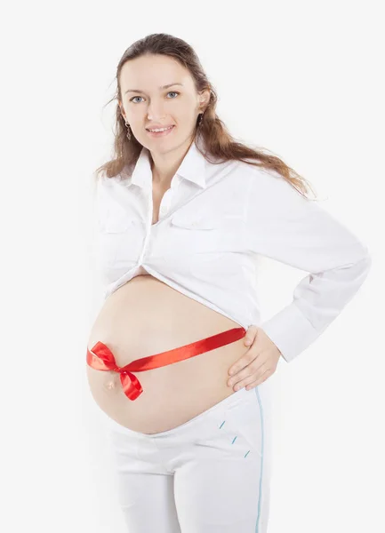 Pregnant woman with red ribbon tied on the stomach — Stock Photo, Image